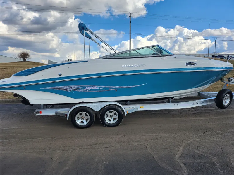 Slide: The Image of 2007 Rinker 246 Captiva Cuddy boat on trailer, blue and white design, parked outdoors. - 4