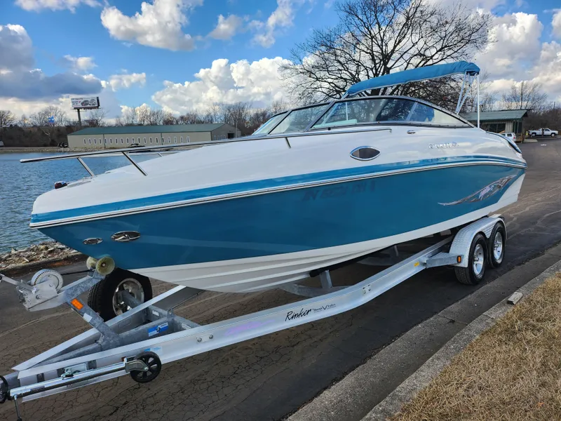 Slide: The Image of 2007 Rinker 246 Captiva Cuddy boat on trailer by a lake under a cloudy sky. - 8