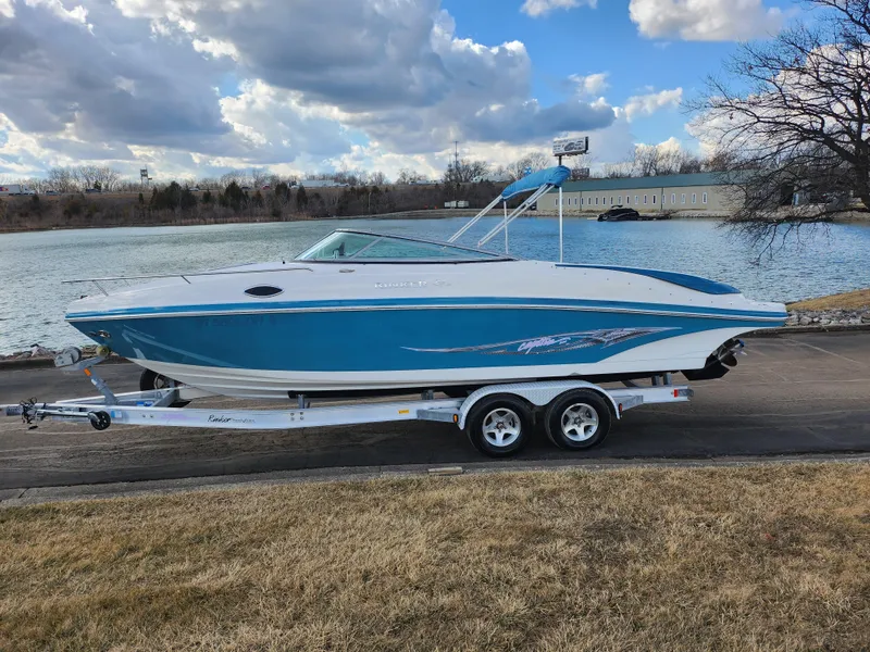 Slide: The Image of 2007 Rinker 246 Captiva Cuddy boat on trailer by a lake under cloudy sky. - 9