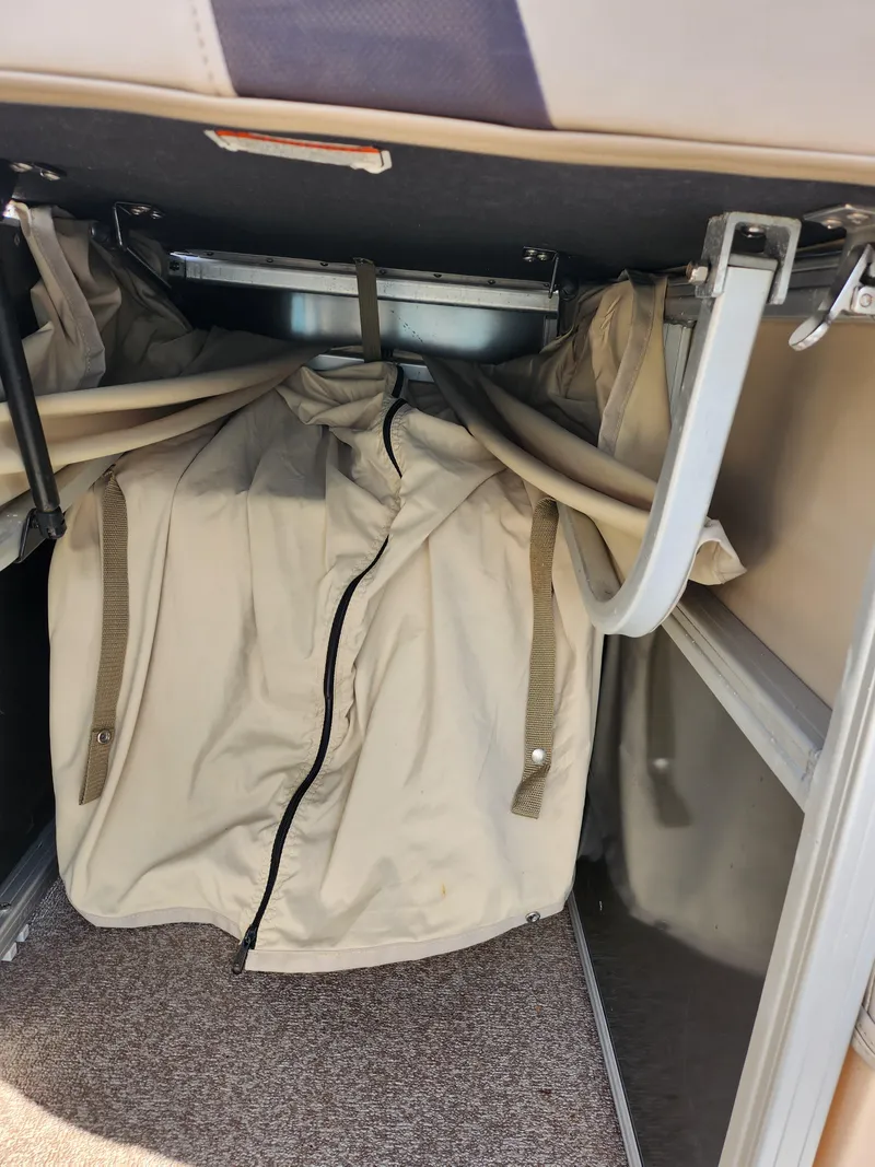 Slide: The Image of Storage compartment in a 2015 Sun Tracker Party Barge 20 DLX with beige cover. - 17