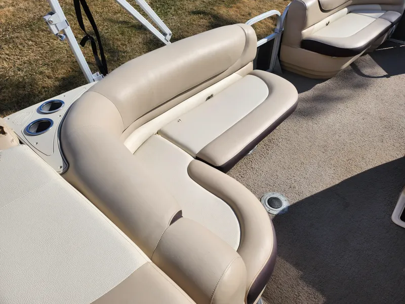Slide: The Image of 2015 Sun Tracker Party Barge 20 DLX interior with beige seating and cup holders. - 19
