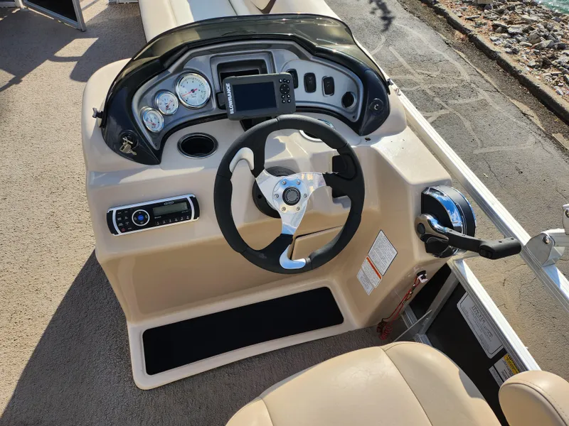 Slide: The Image of 2015 Sun Tracker Party Barge 20 DLX steering console with gauges and controls. - 21