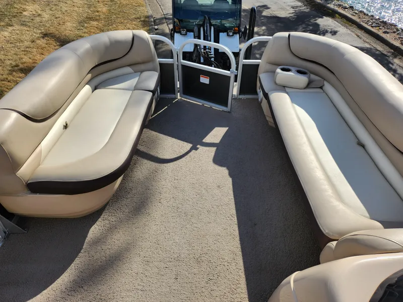 Slide: The Image of 2015 Sun Tracker Party Barge 20 DLX interior with beige seating and carpeted floor. - 23
