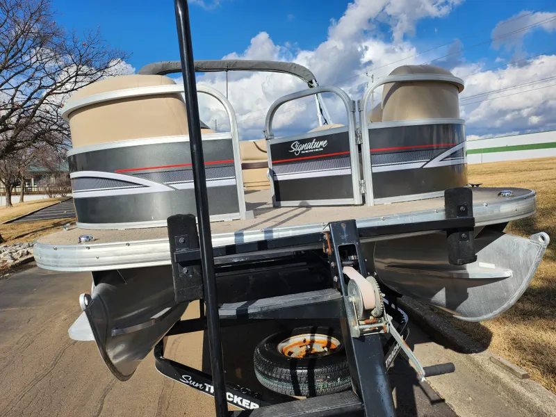 Slide: The Image of 2015 Sun Tracker Party Barge 20 DLX pontoon boat on trailer, parked outdoors. - 6