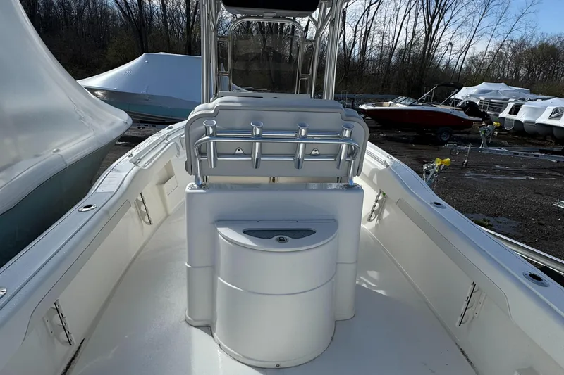 Slide: The Image of 2025 Key West 239FS boat interior with seating and rod holders, docked outdoors. - 9