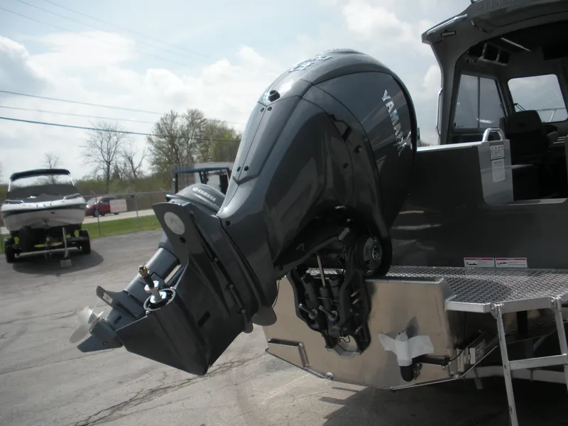 Slide: The Image of Duckworth 24 Pacific Pro 2025 boat with Yamaha outboard motor, parked on a sunny day. - 24