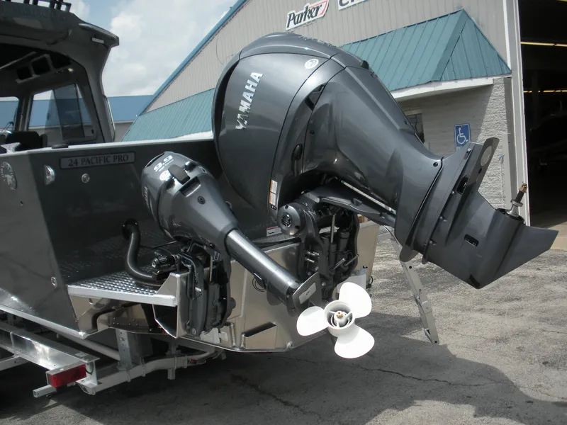 Slide: The Image of 2025 Duckworth 24 Pacific Pro boat with Yamaha outboard motors, parked outside a building. - 25