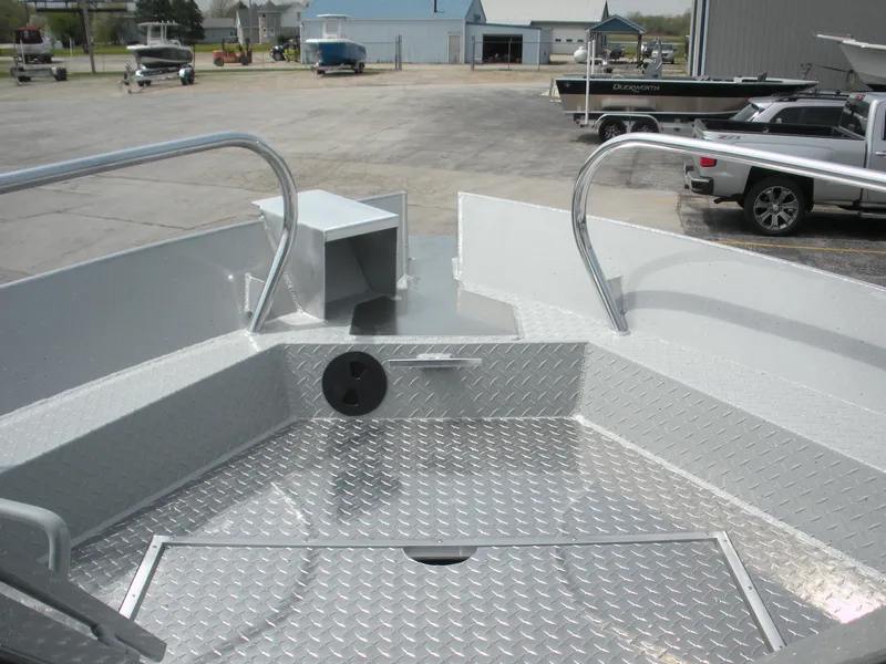 Slide: The Image of Duckworth 24 Pacific Pro 2025 boat deck with diamond plate flooring and railing in a marina. - 6