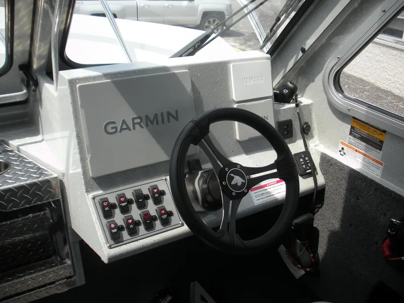 Slide: The Image of 2025 Duckworth 24 Pacific Pro boat dashboard with Garmin navigation system and steering wheel. - 8
