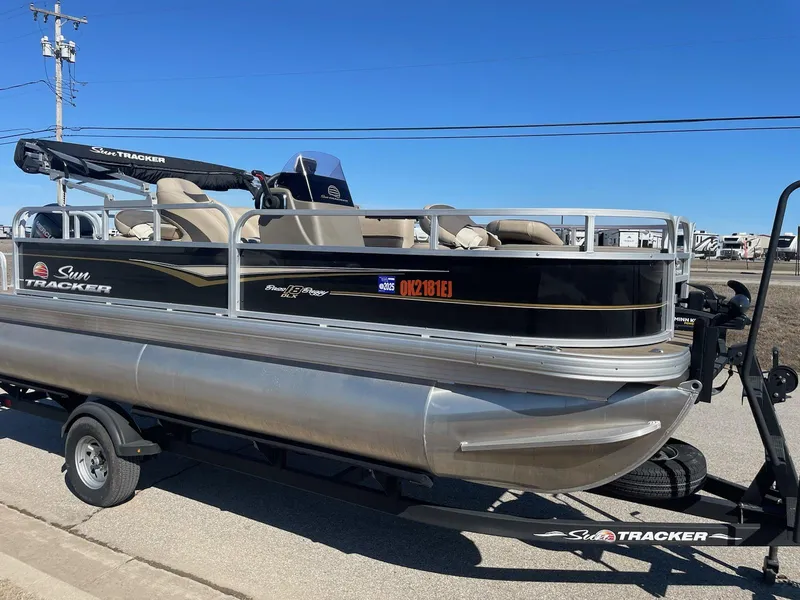 Slide: The Image of 2022 Sun Tracker BB18 pontoon boat on trailer, parked outdoors under clear sky. - 3