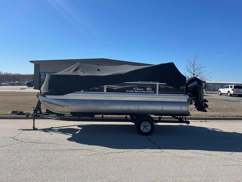 Slide: The Image of 2022 Sun Tracker BB18 pontoon boat with cover on trailer, parked outdoors. - 8