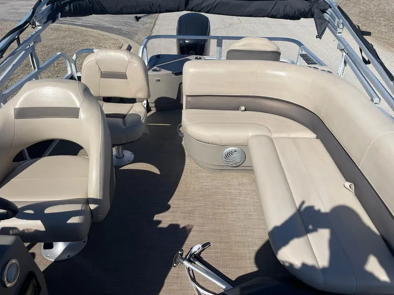 Slide: The Image of 2022 Sun Tracker BB18 boat interior with beige seating and steering console. - 9