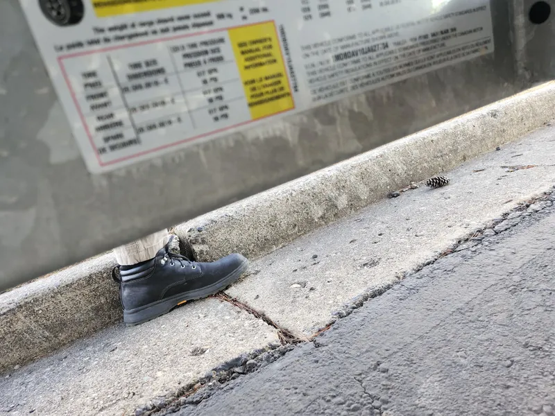 Slide: The Image of A black boot on a concrete curb beside a Qwest LS 7518 Cruise FTL label. - 9