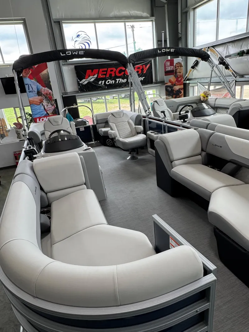 Slide: The Image of 2023 Lowe SS212 Walk-Through pontoon boat with spacious seating in a showroom. - 7