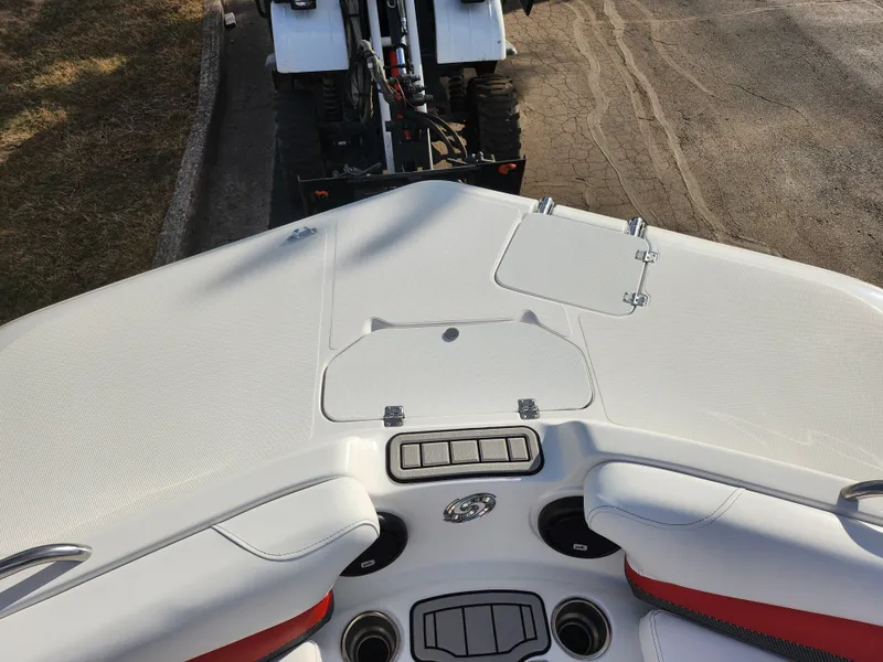 Slide: The Image of 2019 Hurricane SunDeck Sport 202 IO boat interior, featuring white and red seating and storage compartments. - 18