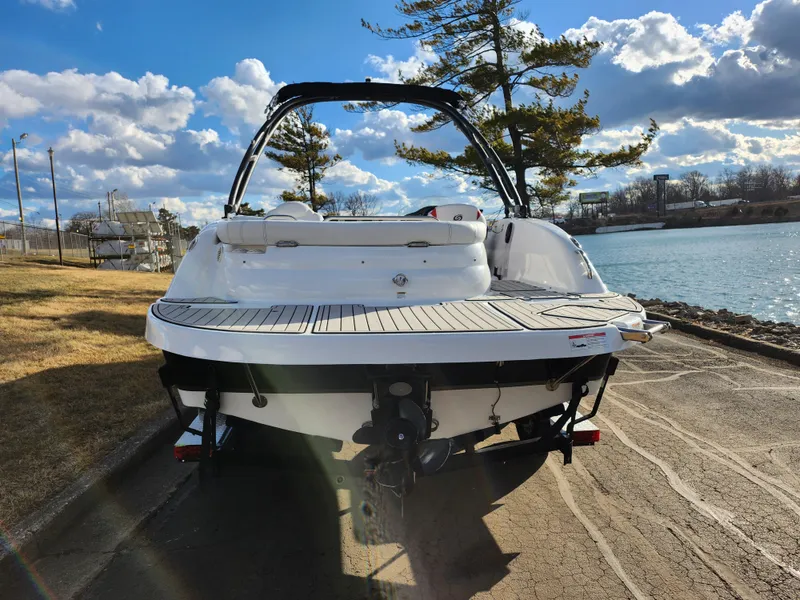 Slide: The Image of 2019 Hurricane SunDeck Sport 202 IO boat by a scenic lakeside. - 2