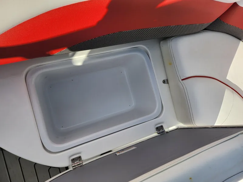 Slide: The Image of 2019 Hurricane SunDeck Sport 202 IO boat storage compartment with red and white seating. - 24