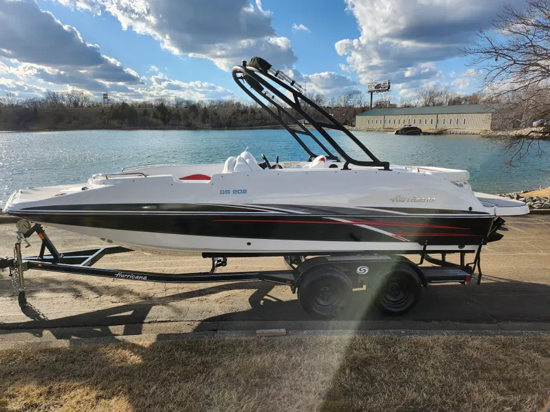 Slide: The Image of 2019 Hurricane SunDeck Sport 202 IO boat on trailer by a lake. - 9