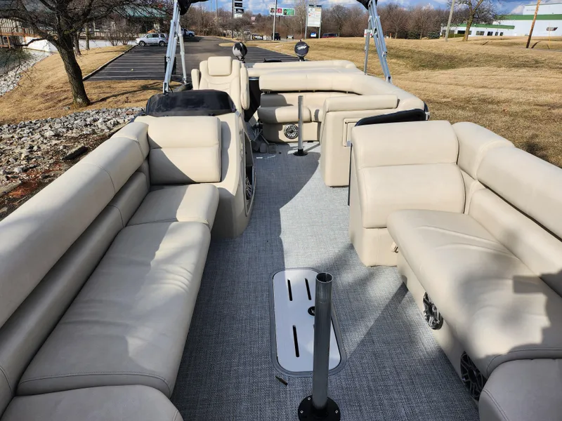 Slide: The Image of 2019 Premier 250 Grand Majestic RE pontoon boat with spacious beige seating and carpeted deck. - 11