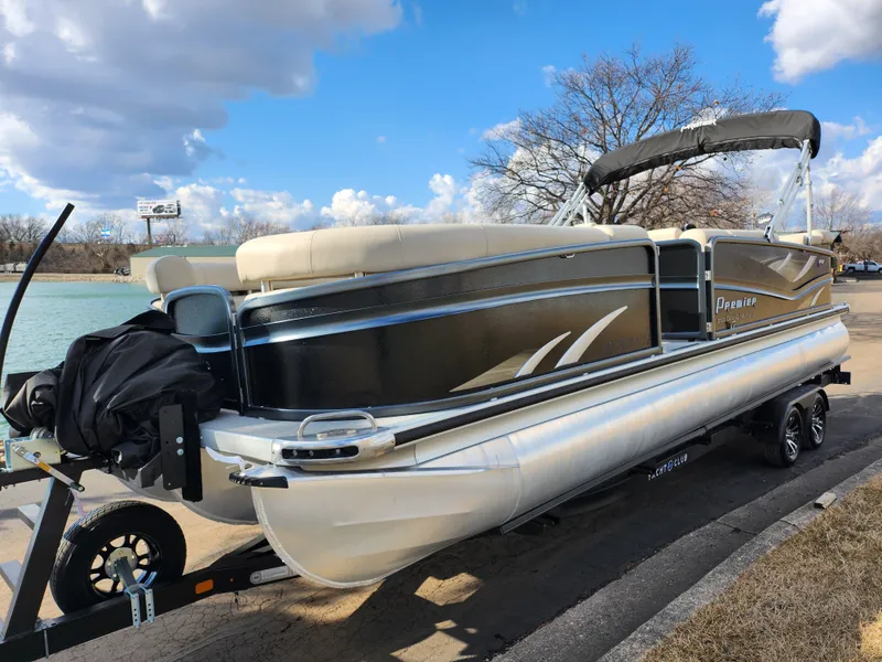 Slide: The Image of 2019 Premier 250 Grand Majestic RE pontoon boat on trailer by a lake. - 9