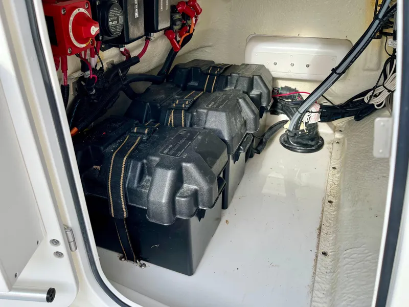 Slide: The Image of Battery compartment of 2023 Boston Whaler 190 Montauk boat, showing secured batteries and wiring. - 18