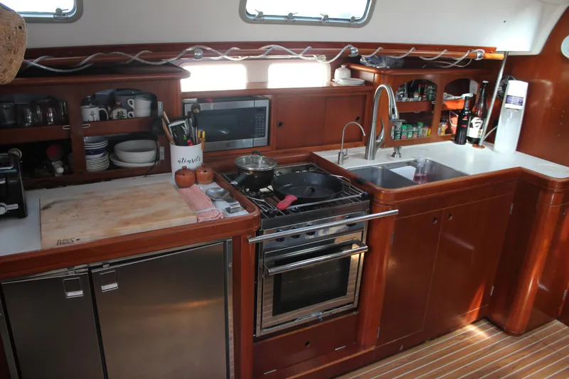 Slide: The Image of Interior kitchen of 1997 Beneteau Oceanis 461 yacht with wooden cabinetry and modern appliances. - 18