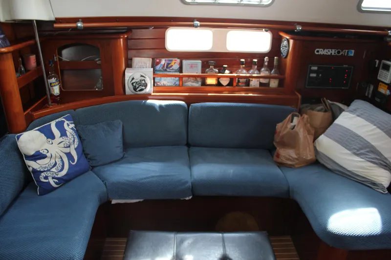 Slide: The Image of Interior of 1997 Beneteau Oceanis 461 sailboat with blue seating and wooden shelves. - 39