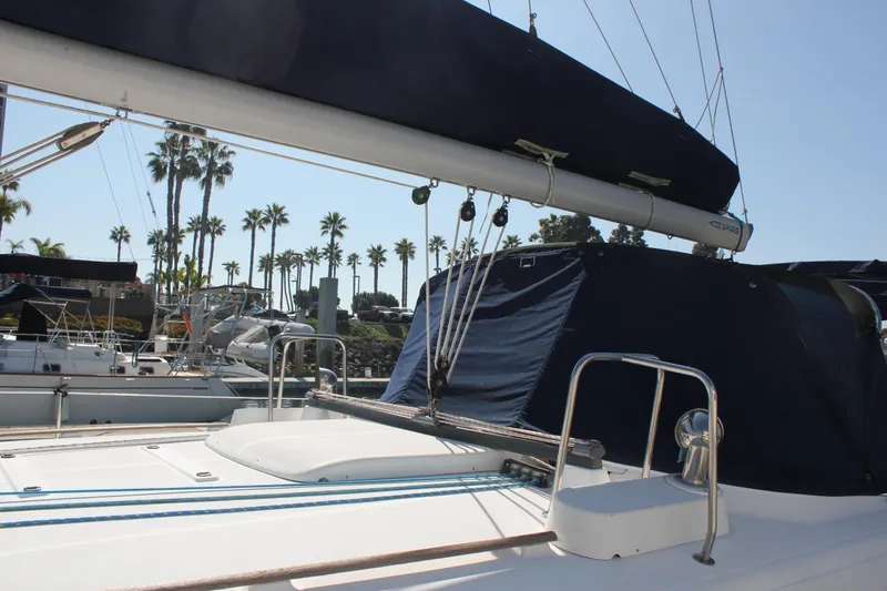 Slide: The Image of 1997 Beneteau Oceanis 461 sailboat docked, featuring deck and rigging, with palm trees in background. - 6