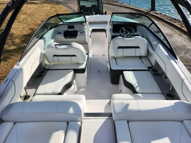 Slide: The Image of 2021 Regal LS2 boat interior with white seating and steering wheel, docked by the water. - 11