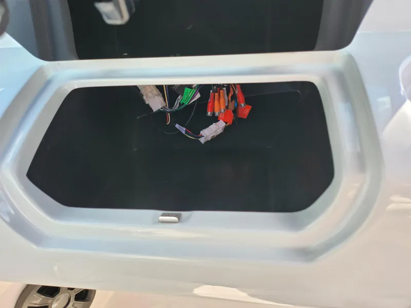 Slide: The Image of Open compartment with visible wiring in a 2021 Regal LS2 boat. - 15