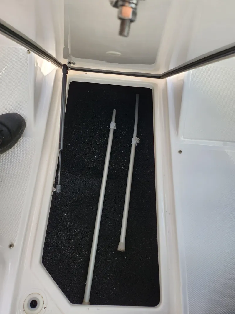 Slide: The Image of 2021 Regal LS2 boat storage compartment with two rods inside. - 17
