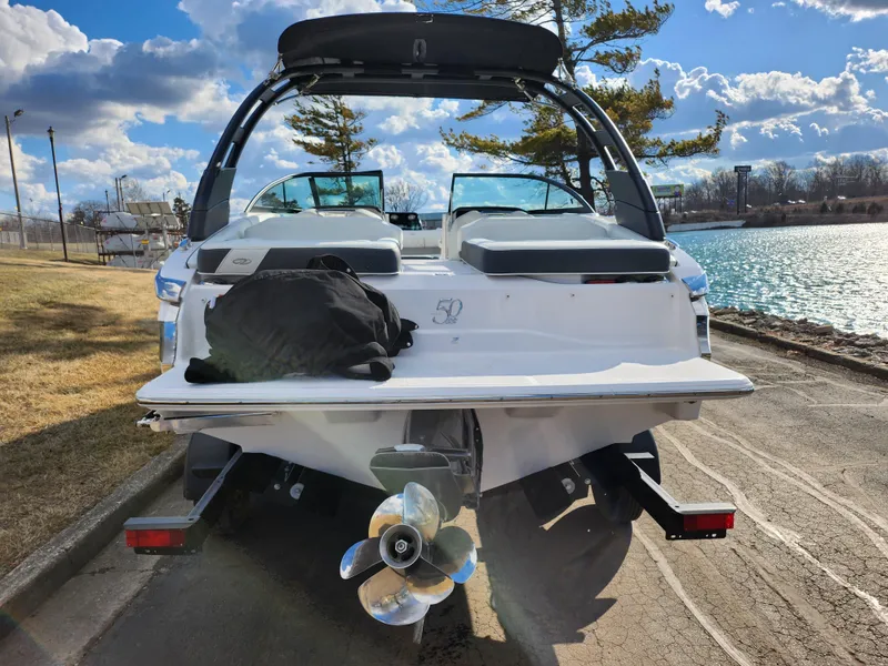 Slide: The Image of 2021 Regal LS2 boat on trailer by a scenic lakeside. - 2