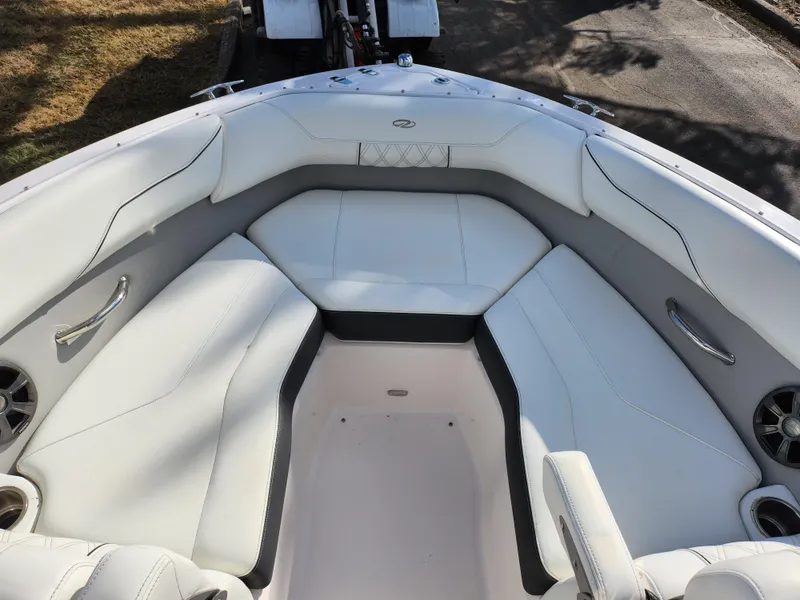Slide: The Image of 2021 Regal LS2 boat interior with white cushioned seating and cup holders. - 20