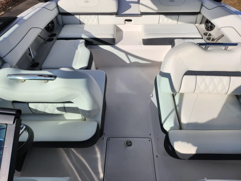 Slide: The Image of 2021 Regal LS2 boat interior with white seating and cup holders. - 24