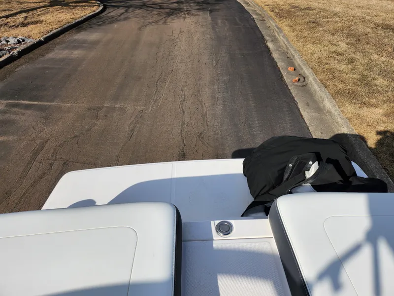 Slide: The Image of 2021 Regal LS2 boat interior with white seats on a sunny day. - 27