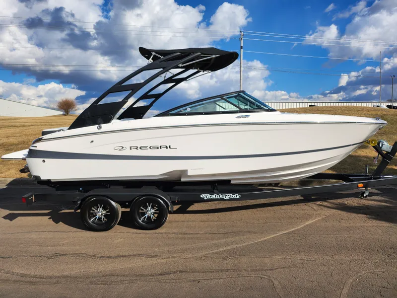 Slide: The Image of 2021 Regal LS2 boat on trailer under a partly cloudy sky. - 4