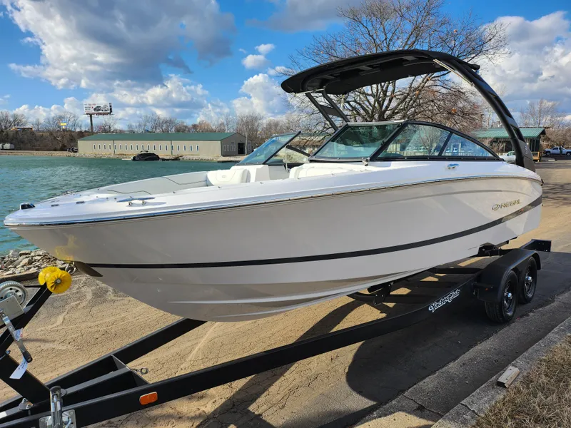 Slide: The Image of 2021 Regal LS2 boat on trailer by waterfront, under a partly cloudy sky. - 8