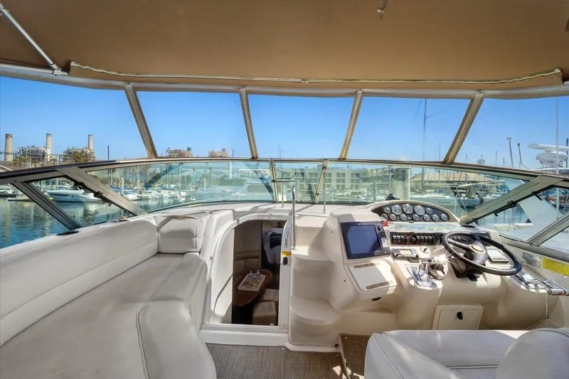 Slide: The Image of 1999 Cruisers Yachts 3870 Esprit cockpit with helm, seating, and marina view. - 13
