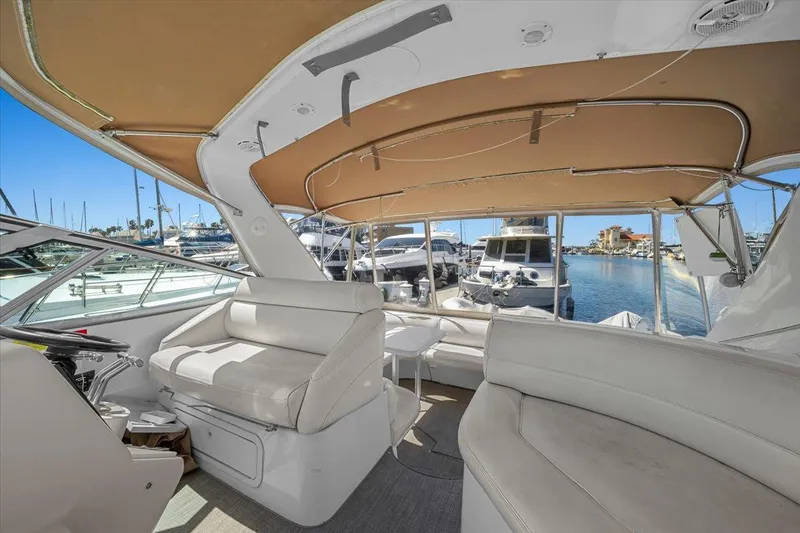 Slide: The Image of 1999 Cruisers Yachts 3870 Esprit interior with white seating and marina view. - 14