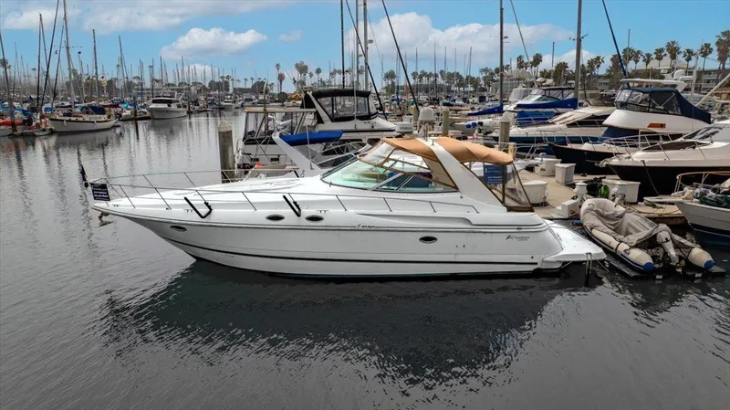 Slide: The Image of 1999 Cruisers Yachts 3870 Esprit docked in a marina, surrounded by other boats. - 5