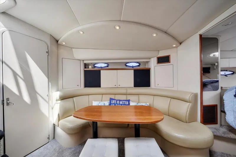 Slide: The Image of 1999 Cruisers Yachts 3870 Esprit interior with curved seating and wooden table. - 21