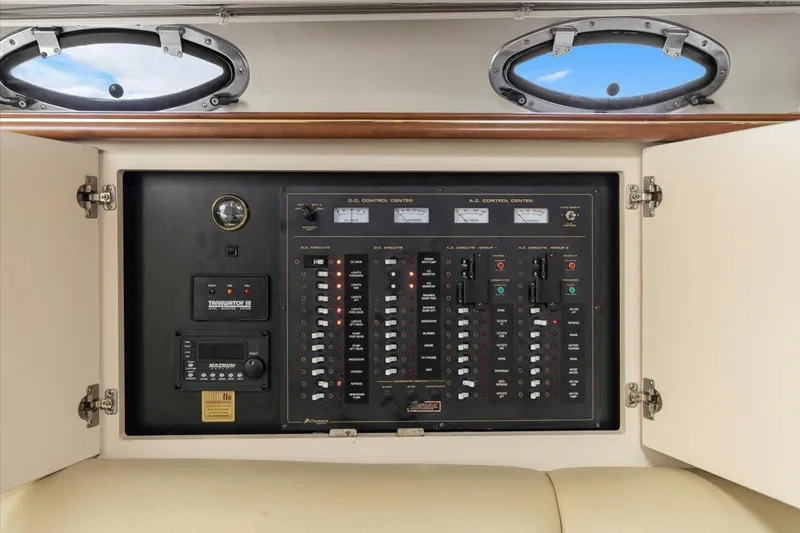 Slide: The Image of Electrical control panel inside 1999 Cruisers Yachts 3870 Esprit, featuring switches and gauges. - 26