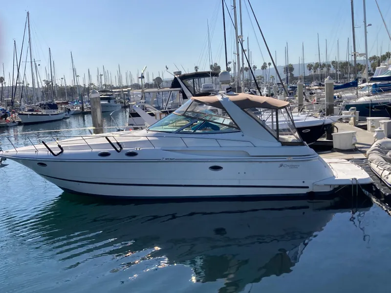 Slide: The Image of 1999 Cruisers Yachts 3870 Esprit docked in a marina, surrounded by sailboats. - 3