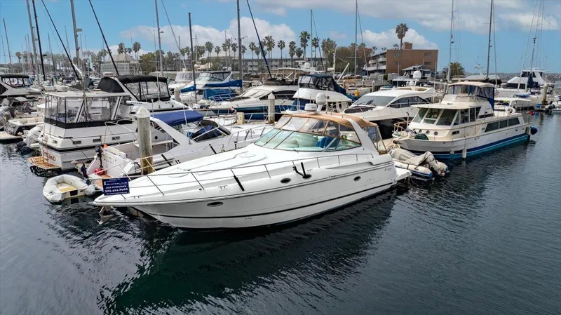 Slide: The Image of 1999 Cruisers Yachts 3870 Esprit docked in a marina, surrounded by other boats. - 6