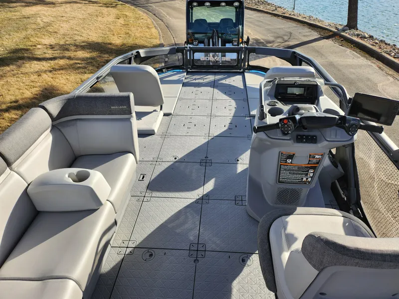 Slide: The Image of 2022 Sea-Doo Switch Cruise 21 pontoon boat interior with seating and steering console. - 17
