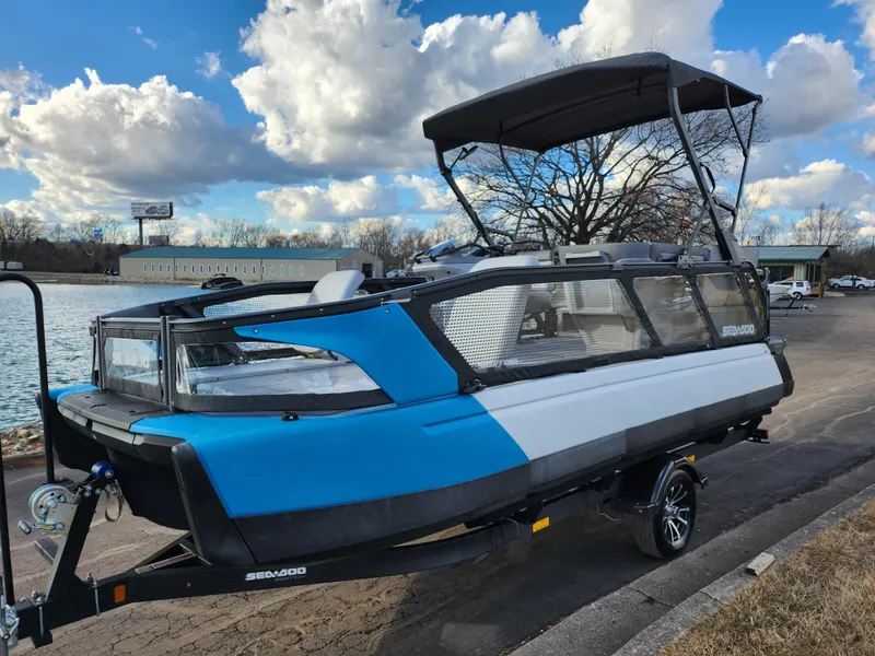 Slide: The Image of 2022 Sea-Doo Switch Cruise 21 pontoon boat on trailer by a lake. - 8