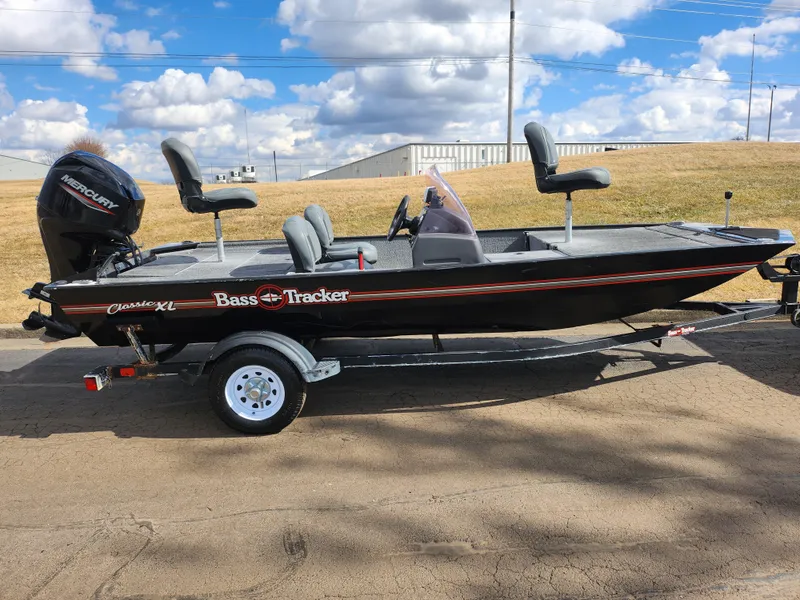 Slide: The Image of 2021 Tracker Bass Tracker Classic XL fishing boat on trailer, under a partly cloudy sky. - 4