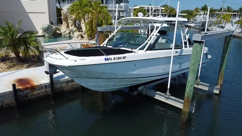 The Image of 2019 Boston Whaler 270 Vantage boat docked on a lift in a marina. - 1