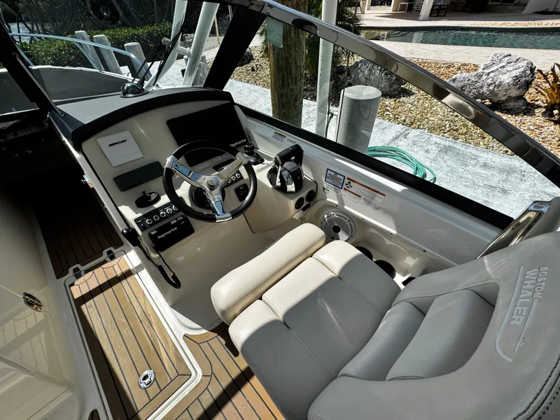 Slide: The Image of 2019 Boston Whaler 270 Vantage boat cockpit with steering wheel and seating. - 22