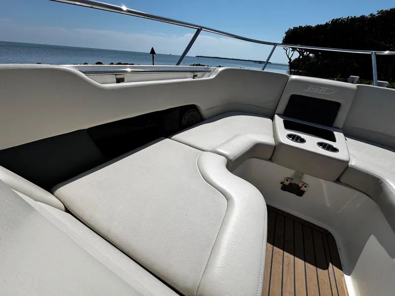 Slide: The Image of 2019 Boston Whaler 270 Vantage boat interior with cushioned seating and cup holders. - 28